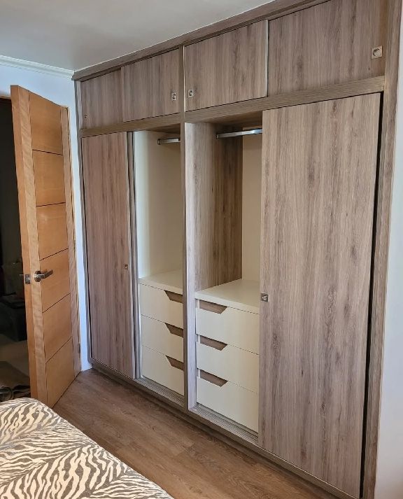 Armario correlero de madera en un dormitorio de Ferrol, con cajones y barra para colgar