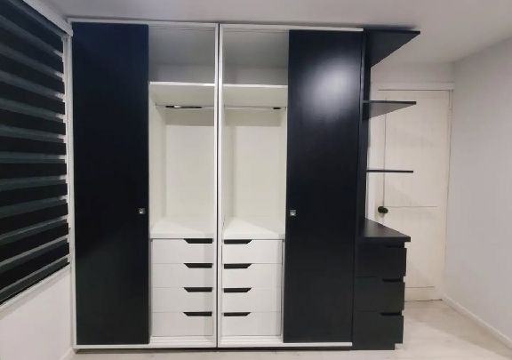 Interior de armario lacado en negro y blanco con barra de colgar y cajonera