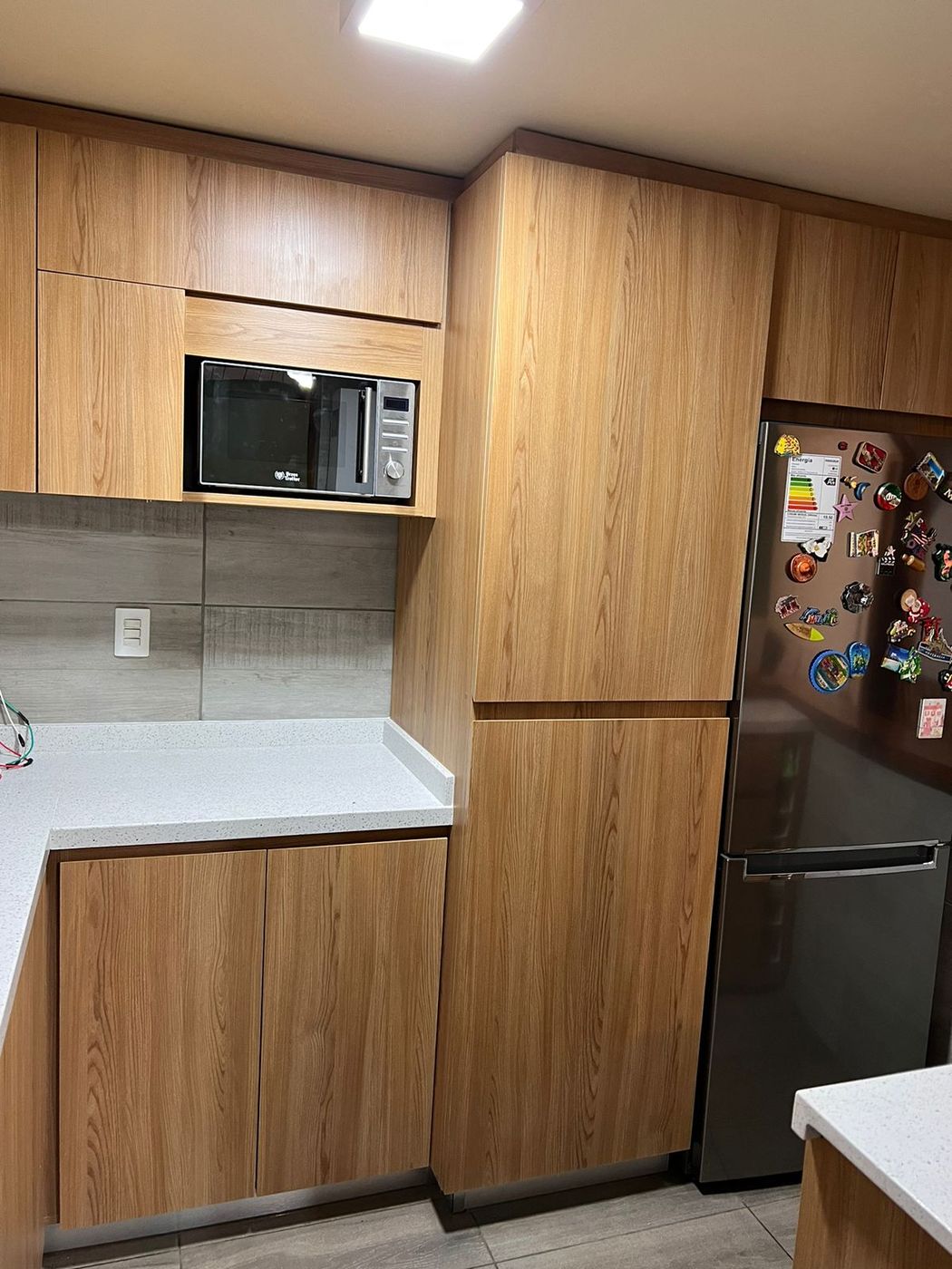 Columna de cocina en madera roble con microondas empotrado y frigorífico combi