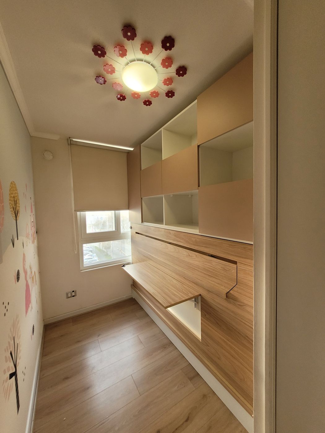Mueble infantil con estantería en tonos pastel y escritorio abatible en madera