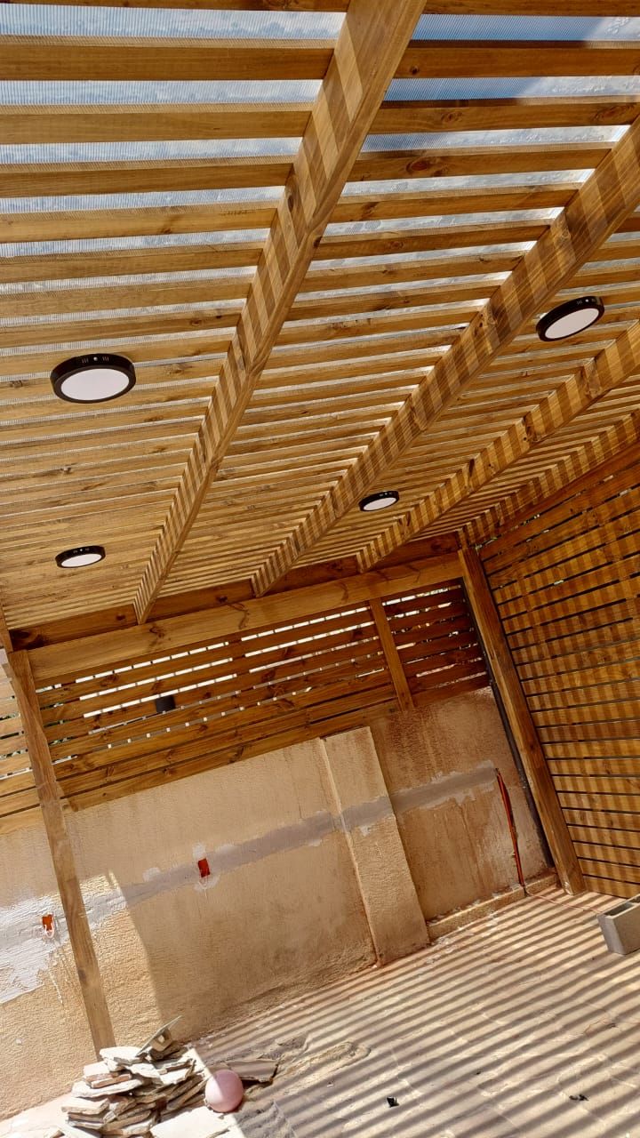Pérgola de madera con techo de policarbonato traslúcido y focos empotrados