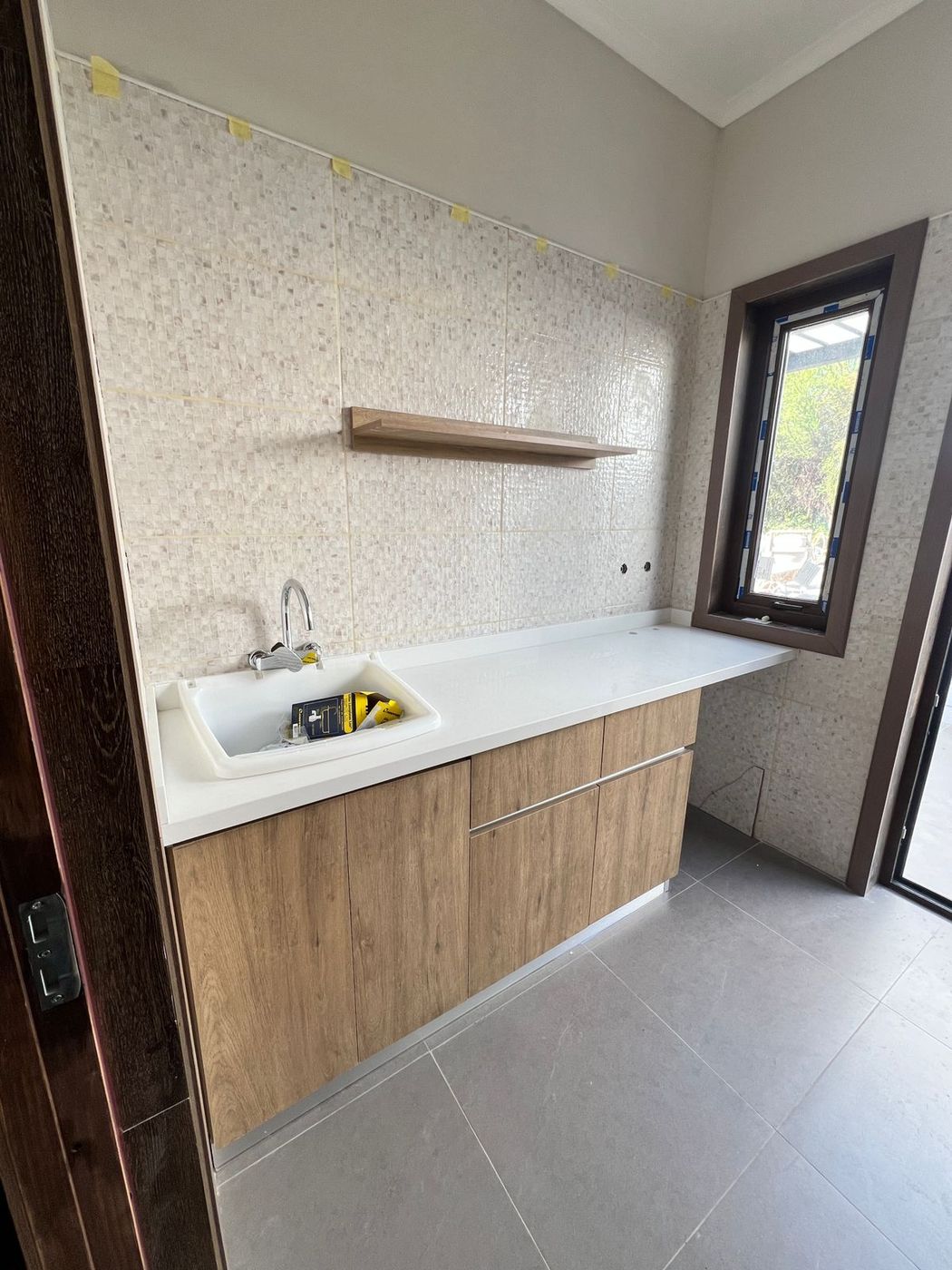 Encimera y fregadero de cocina auxiliar en madera clara con azulejo de mosaico